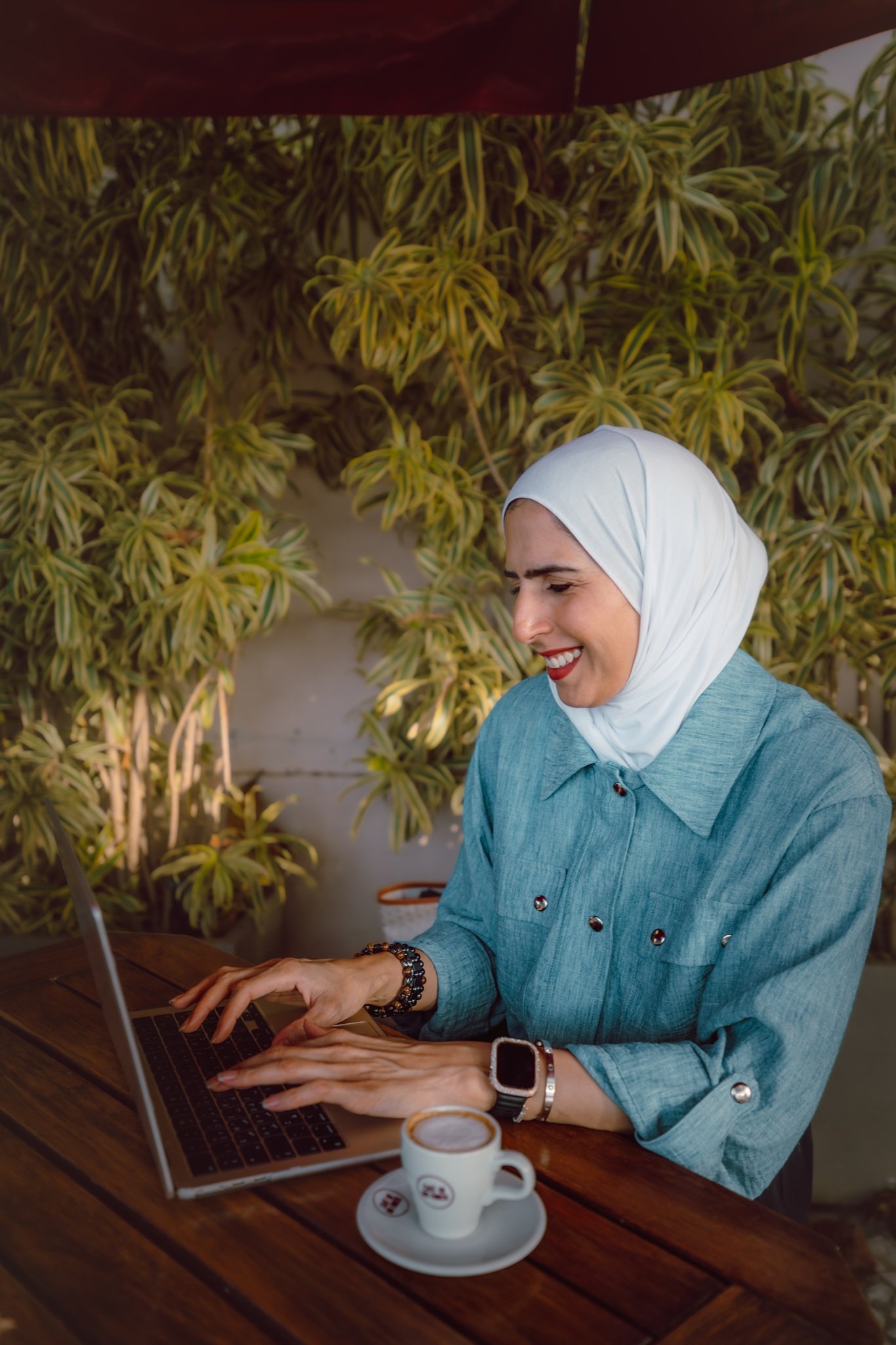 Arwa Al Turkait sitting in front of a bookshelf